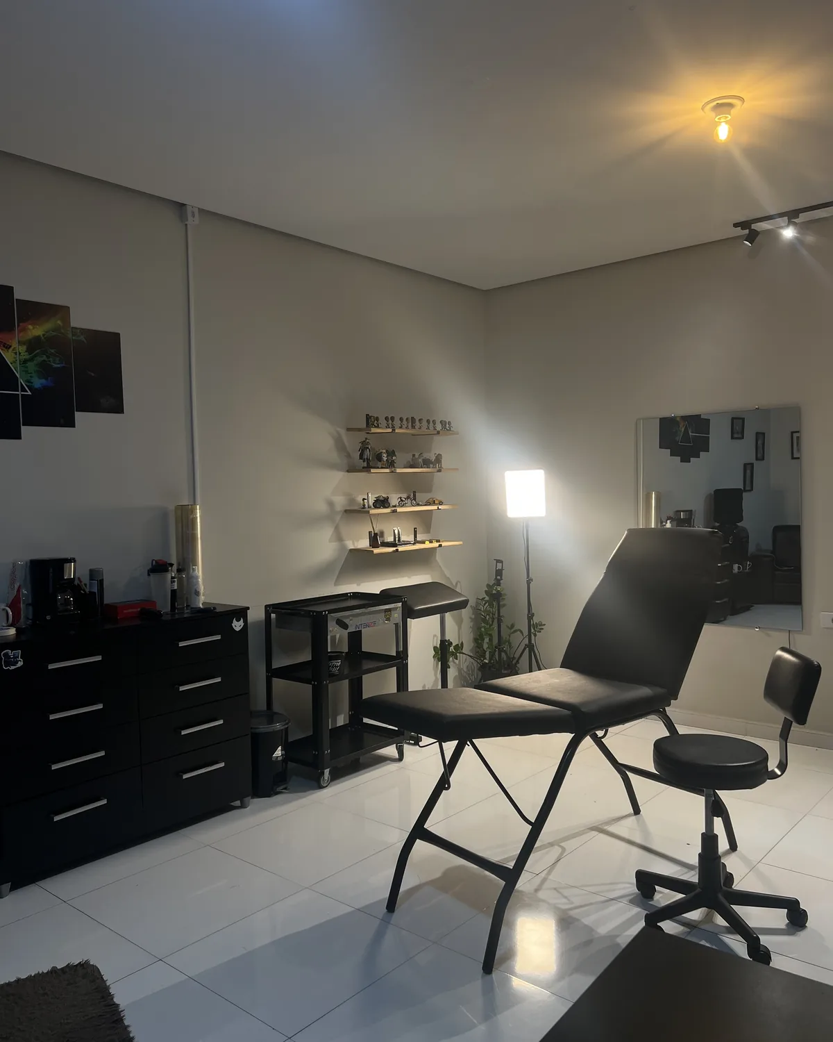 Sala de tatuagem do estúdio, com maca, iluminação e materiais organizados