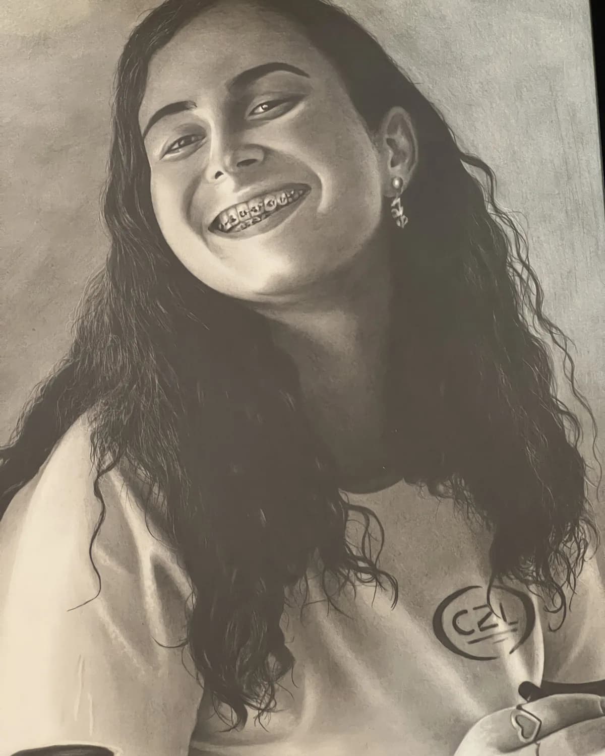Desenho realista a grafite de uma jovem sorrindo, feito à mão pelo Matheus